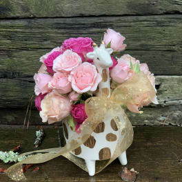 Pink rose bouquet in a giraffe-shaped vase with a gold ribbon