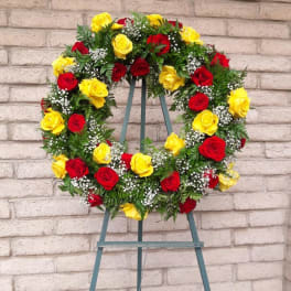 Circular wreath of red and yellow roses on a stand