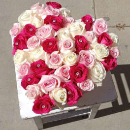 Heart-shaped bouquet of pink, white, and red roses