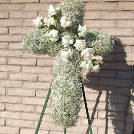 White floral cross on a stand with small white roses