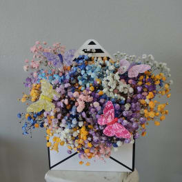 Colorful dried flower bouquet in a white envelope box with butterfly decorations