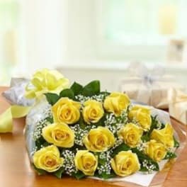 Bouquet of yellow roses with baby's breath wrapped in paper
