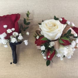 Two rose boutonnieres with baby's breath on a burlap background