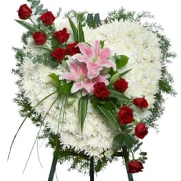 Heart-shaped white mum wreath with red roses and pink lilies on a standing easel