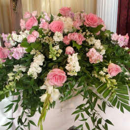 Large pink and white floral casket spray with cascading greenery