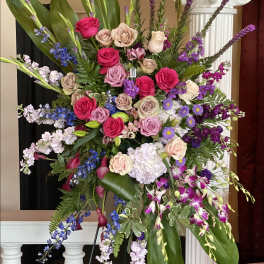Large standing floral spray with pink, purple, and white blooms
