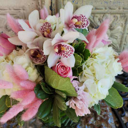 Pink and white bouquet with orchids, roses, hydrangeas, and fluffy pink accents