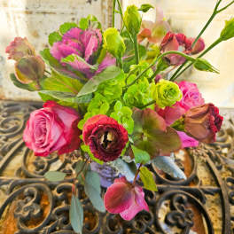 Bouquet of pink roses and green blooms in a vase