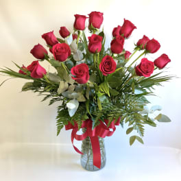 Bouquet of red roses in a glass vase with a red ribbon