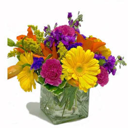 Bright mixed bouquet in a square glass vase