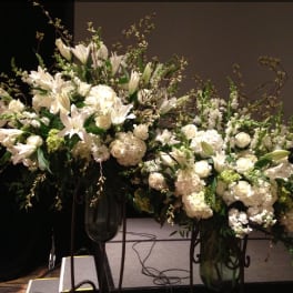Large white floral arrangements in tall glass vases