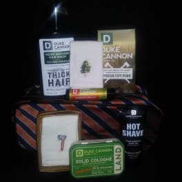 Assorted Duke Cannon grooming products arranged on a striped tie.