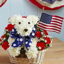 White teddy bear made of flowers in a basket with a small American flag