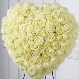 Heart-shaped arrangement of ivory roses on a stand