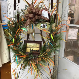 Tall decorative wreath with fish accents, ribbon, and a framed sign