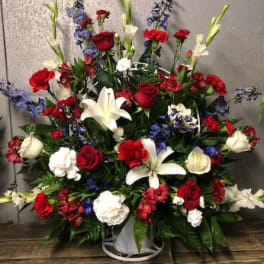 Large red, white, and blue floral spray in a white container