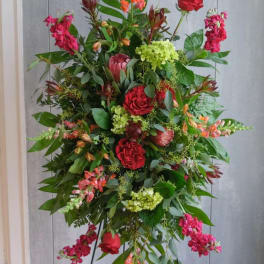 Tall standing floral spray with red roses and pink blooms