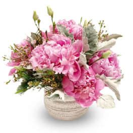 Pink peonies in a speckled ceramic vase with silvery foliage