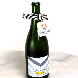 Bottle of sparkling wine with a striped ribbon and hanging tag