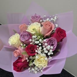 Bouquet of multicolored roses wrapped in lavender paper