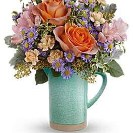 Peach roses and purple daisies in a turquoise mug vase