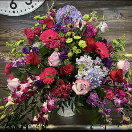 Large mixed bouquet with roses, gerbera daisies, hydrangeas, and orchids in a vase