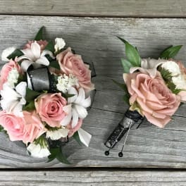 Pink rose bouquet and matching boutonniere with white flowers and black ribbon