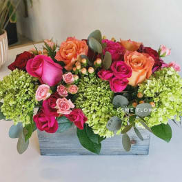 Mixed roses and green hydrangeas in a wooden box