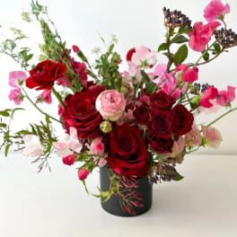Red and pink roses arranged in a black vase