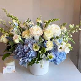 Blue and white floral arrangement in a white vase