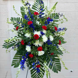 Large standing floral spray with red, white, and blue flowers on an easel