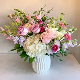Pink and white rose bouquet in a white vase