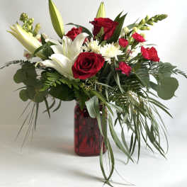 Bouquet of red roses, white lilies, and white mums in a red glass vase