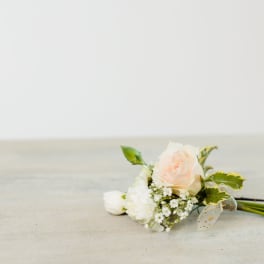 Small pale pink rose boutonniere with white flowers