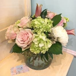 Pink roses and green hydrangeas in a glass vase