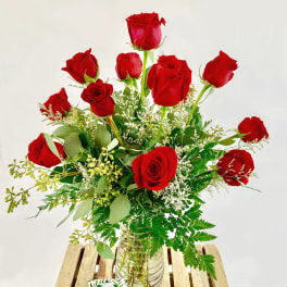 Red roses arranged in a clear glass vase