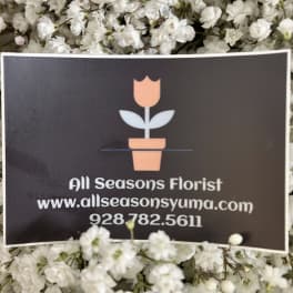 White baby's breath surrounds a florist business card