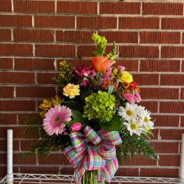 Mixed bouquet in a glass vase with a plaid bow