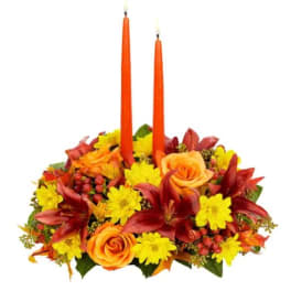 Autumn floral centerpiece with two orange taper candles