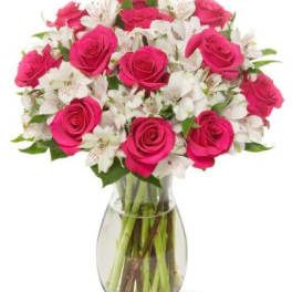 Pink roses and white alstroemeria in a clear glass vase