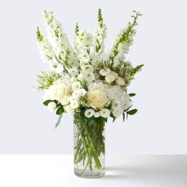 White floral arrangement in a tall clear glass vase