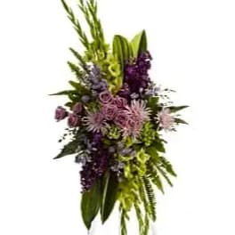 Tall floral spray with purple and green flowers on a stand
