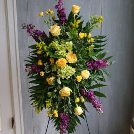 Tall standing floral spray with yellow roses and purple flowers