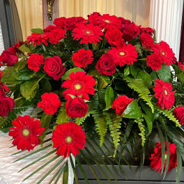 Red roses and gerbera daisies arranged in a casket spray