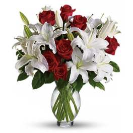 Bouquet of red roses and white lilies in a clear glass vase