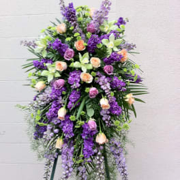 Tall standing floral spray with purple and peach roses