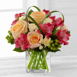 Bouquet of peach roses and pink alstroemeria in a clear glass vase