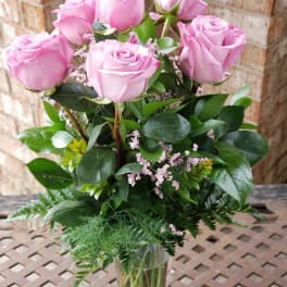 Pink roses arranged in a clear glass vase