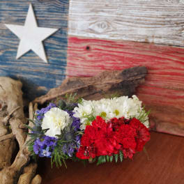 Red, white, and blue floral arrangement with carnations and daisies