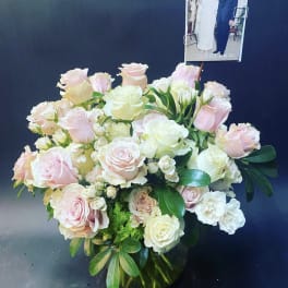Bouquet of pale pink and white roses with a photo card